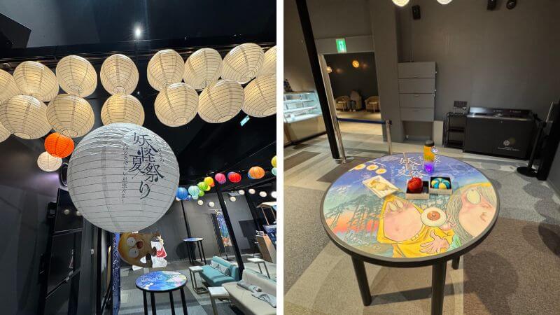 提灯と鬼太郎の装飾がある妖怪茶房の休憩スペースとコラボフードを置いたテーブル
